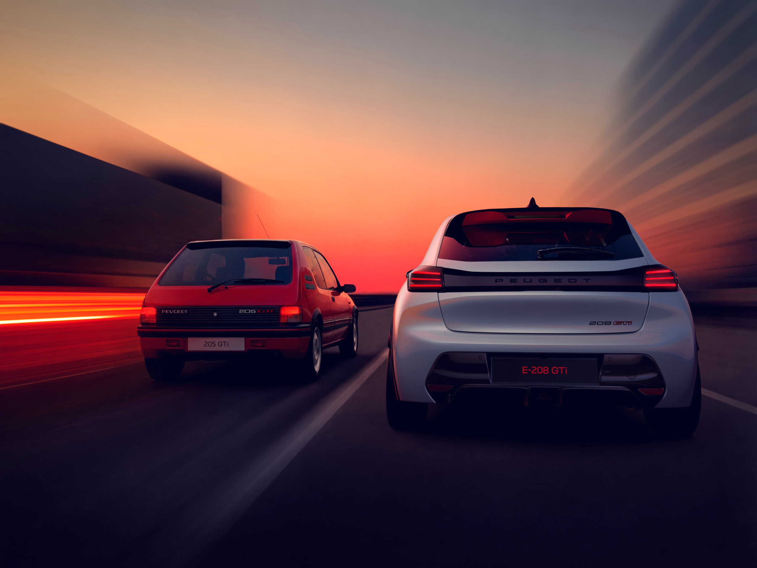 The original 205 GTi alongside the new Peugeot E-208 GTi