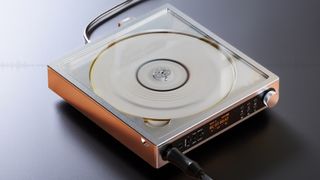 A 3/4 shot of the FiiO DM15 R2R portable CD player on a grey surface.