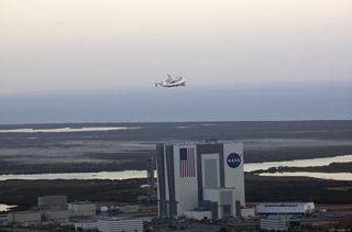 Shuttle Carrier Aircraft Carrying Discovery over Vehicle Assembly Building