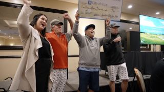A group of happy golfers hold up a big check after winning the Spinitar Golf for Hope.