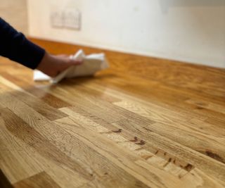 wiping excess countertop oil of wooden countertop with lint-free cloth