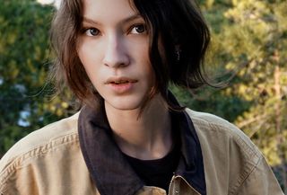 Woman wearing khaki and dark brown Zara barn coat jacket.