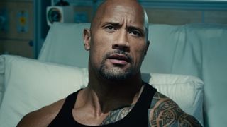 Dwayne Johnson sits upright in a hospital bed in Furious 7