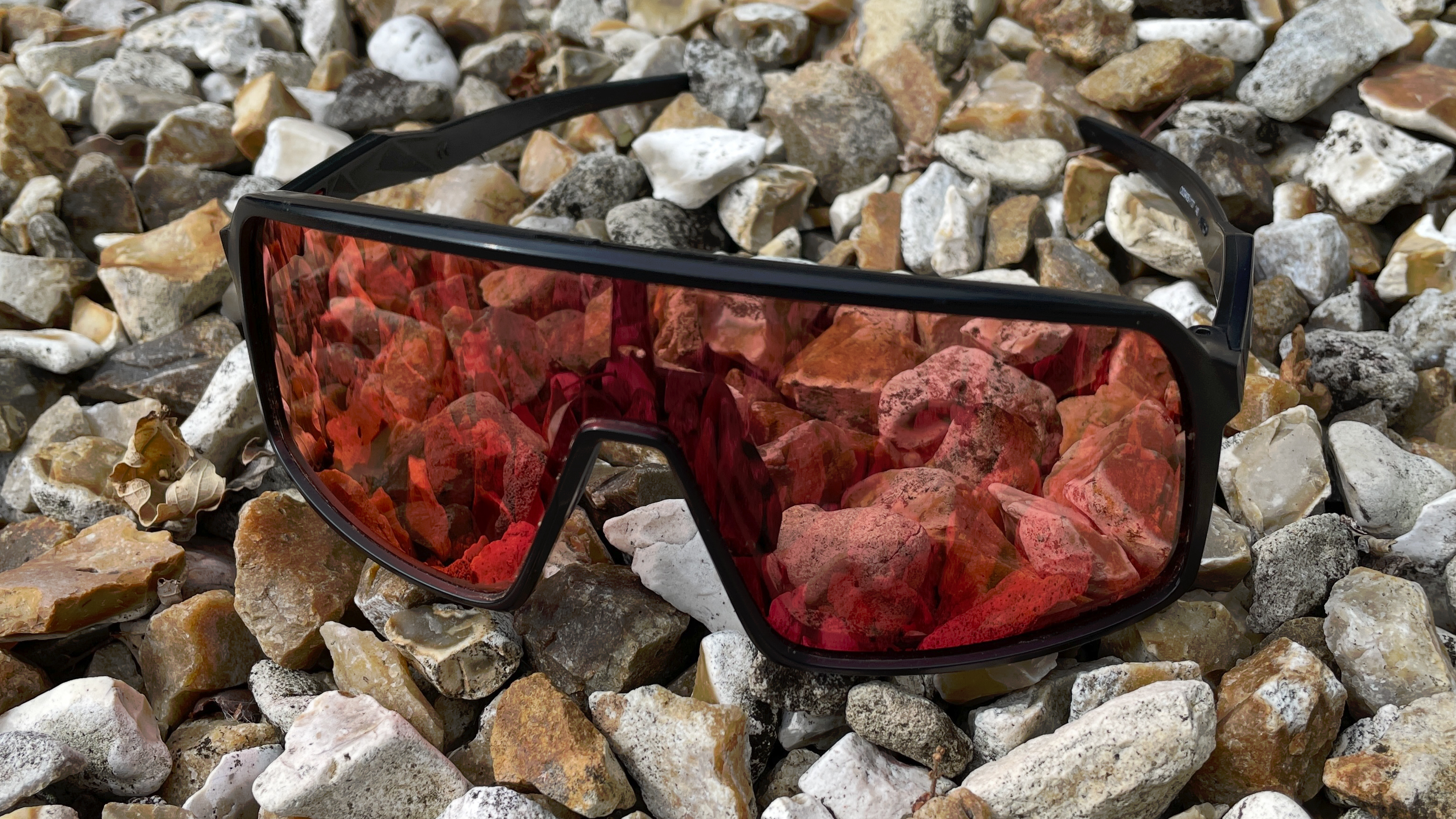 A pair of Oakley Sutro sunglasses on a pile of stone chippings