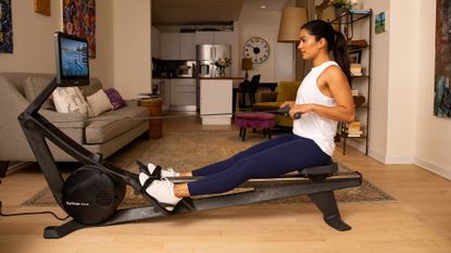Best rowing machine: Pictured here, attractive young woman using the Hydrow Wave in a small apartment