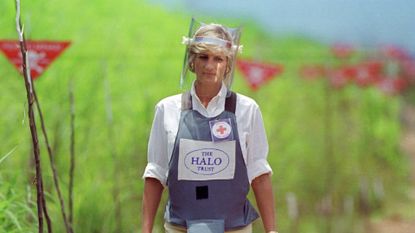 Princess Diana wears body armour and a face visor while walking across a landmine minefield being cleared by the charity Halo in Huambo, Angola