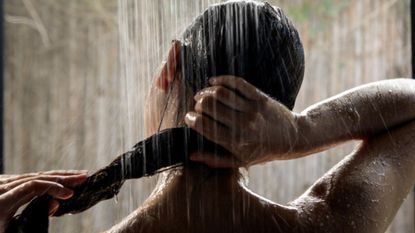 best hard water beauty products - woman in shower wringing out her hair 