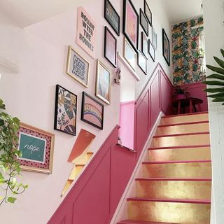 hallway with bold pink stairs and frames on wall