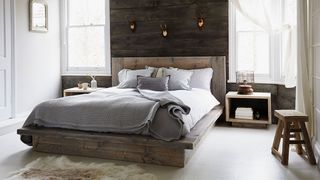 small bedroom with wooden panelling and platform bed