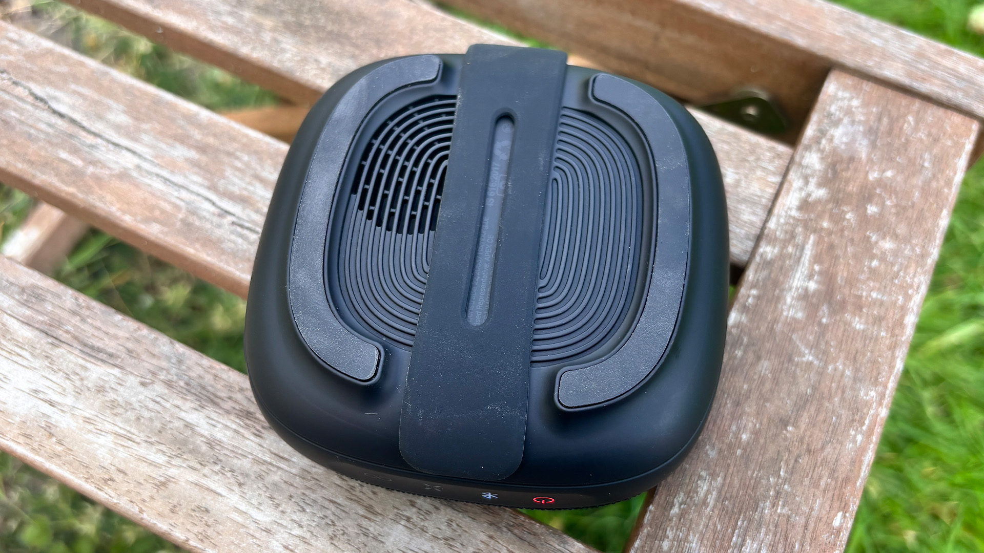 Tribit Stormbox Micro 3 Bluetooth speaker on wooden bench showing rear of speaker