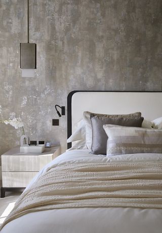bedroom with gold wallpaper and linen
