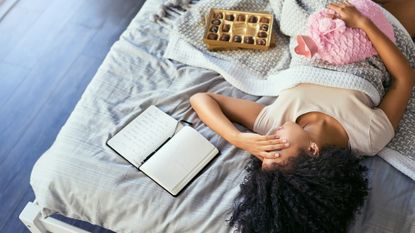 woman lying on her bed with period cramps