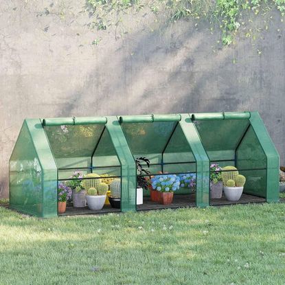 Outsunny greenhouse with the walls rolled up and plants inside