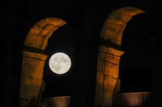 full moon between two large stone arches.