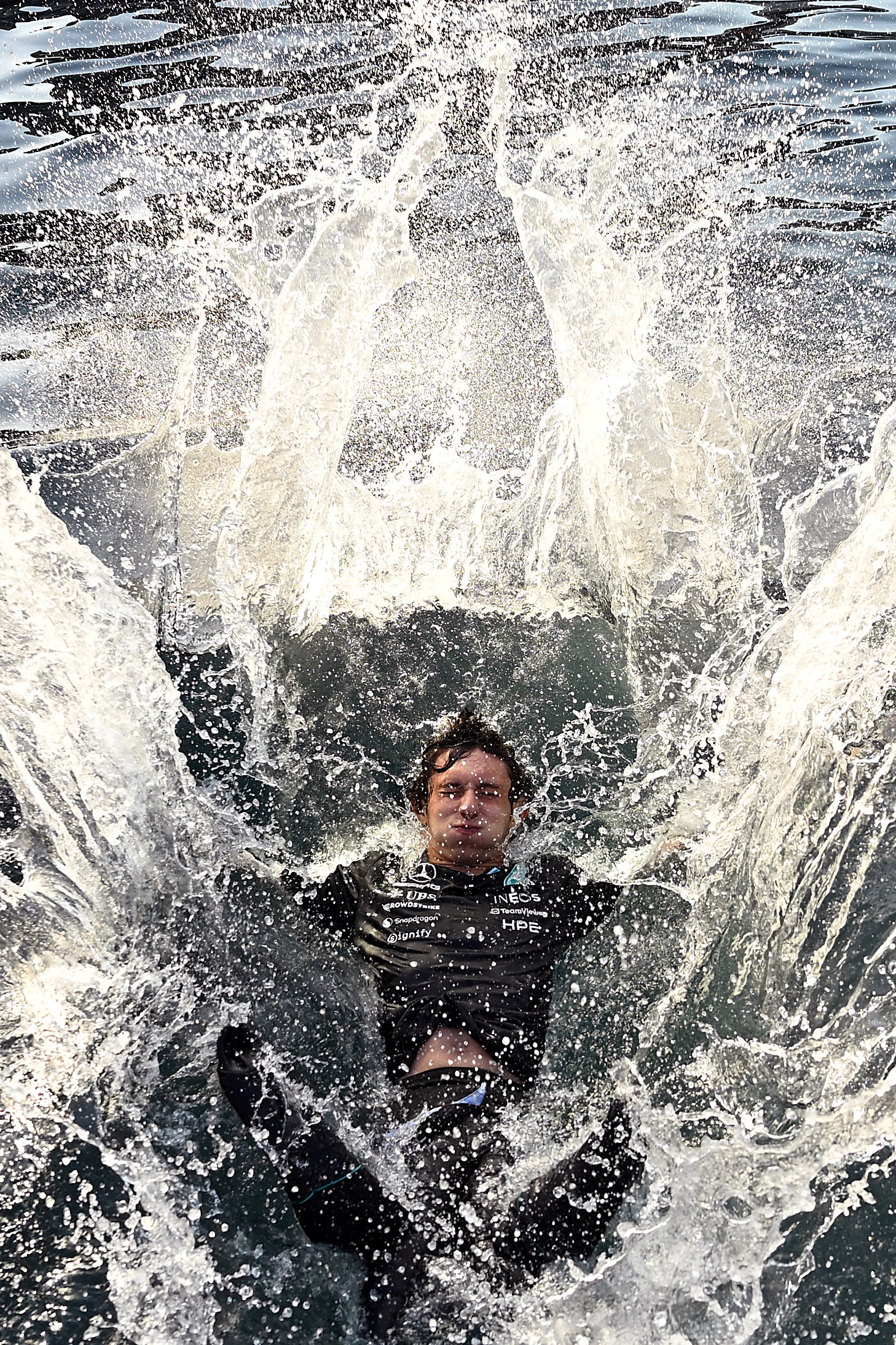Kimi Antonelli falling backwards into the sea, wearing a black t-shirt