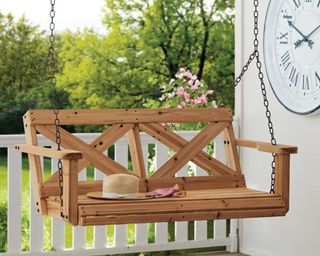 A solid wood 2-person porch swing, available from Wayfair