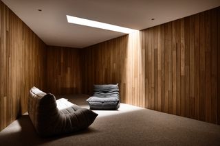 Snug room with oak slated walls and 2 grey comfort chairs