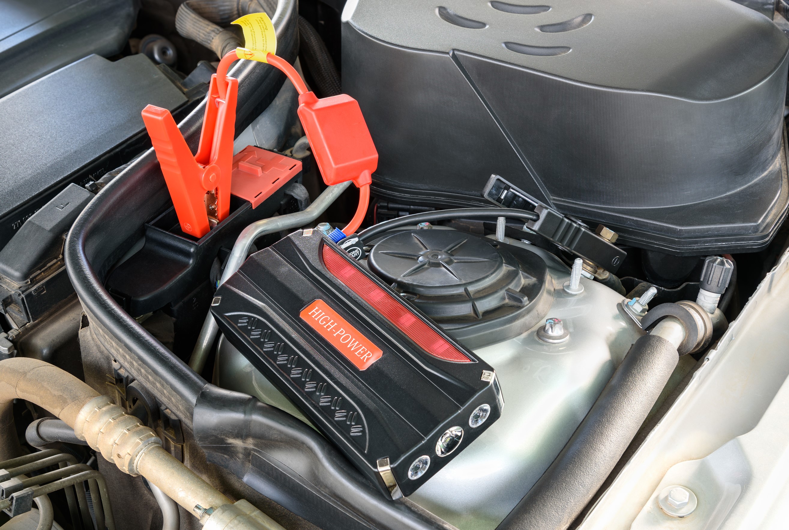 car battery hooked up to jump start booster pack
