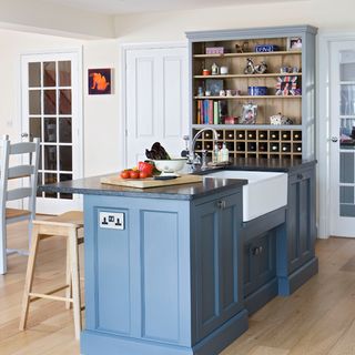 white kitchen with painted blue island unit