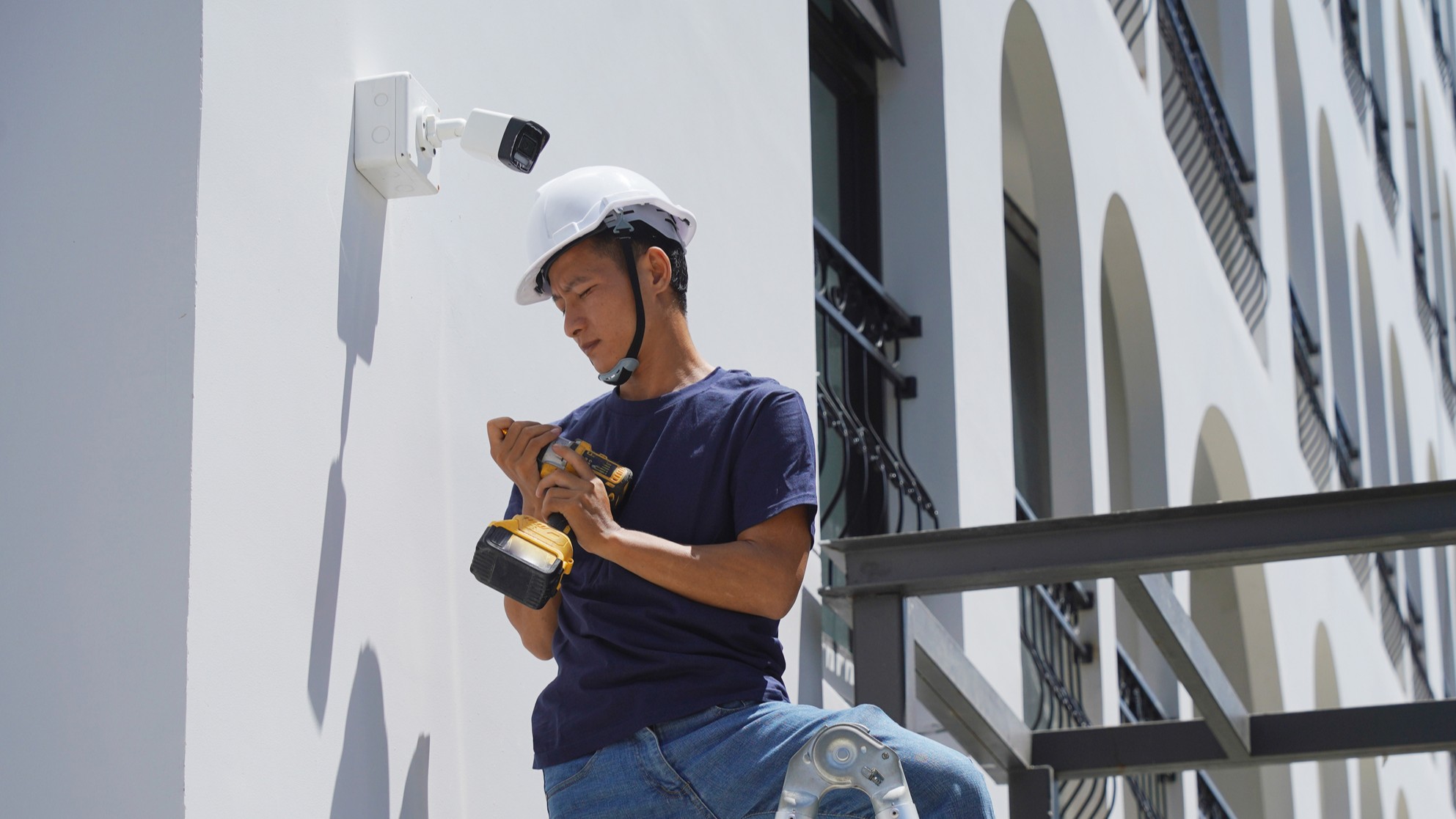 Technician installing exterior security camera