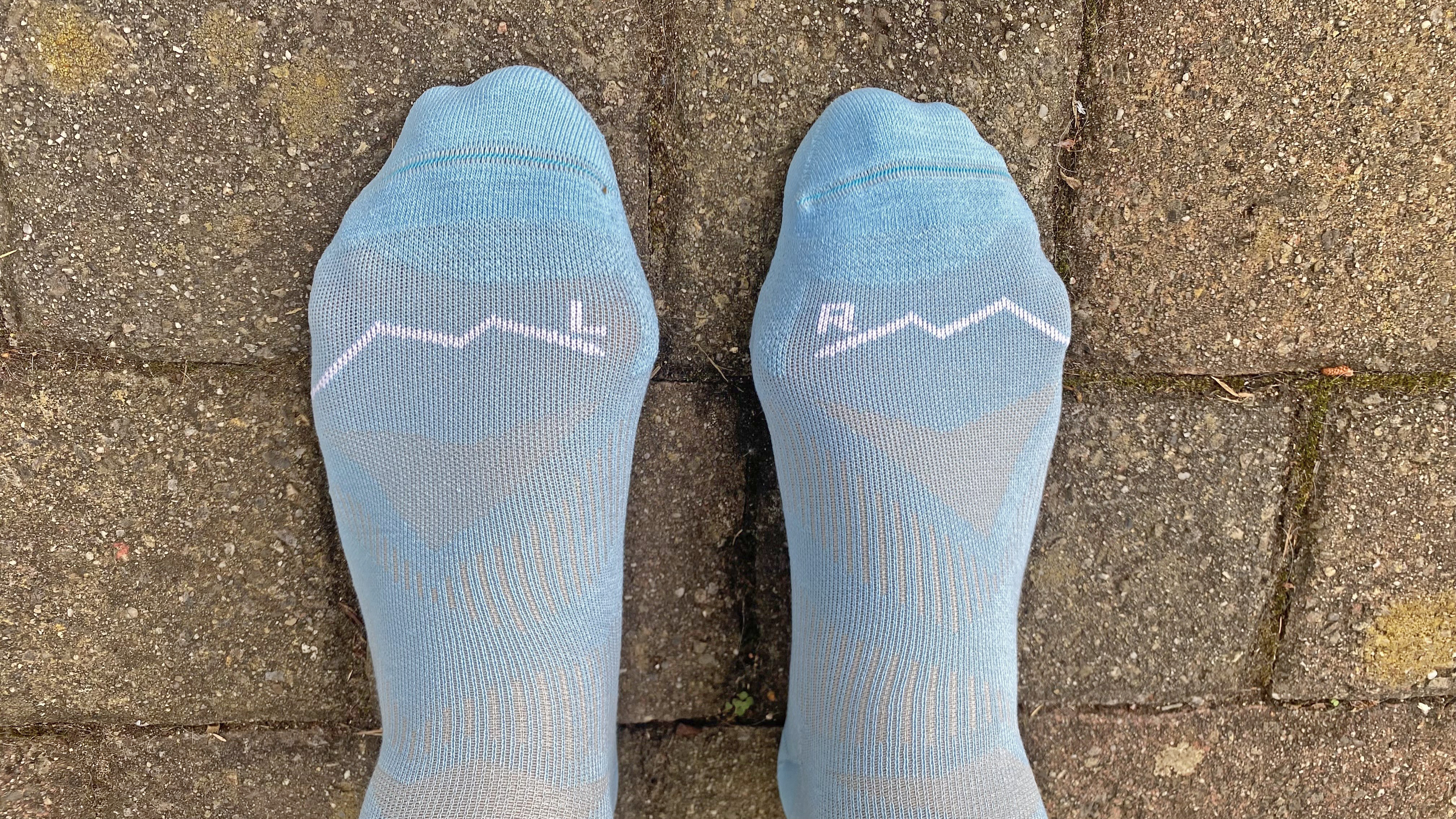 Runner wearing the Buff CoolNet Crew running socks, showing left/right specification and mesh panels