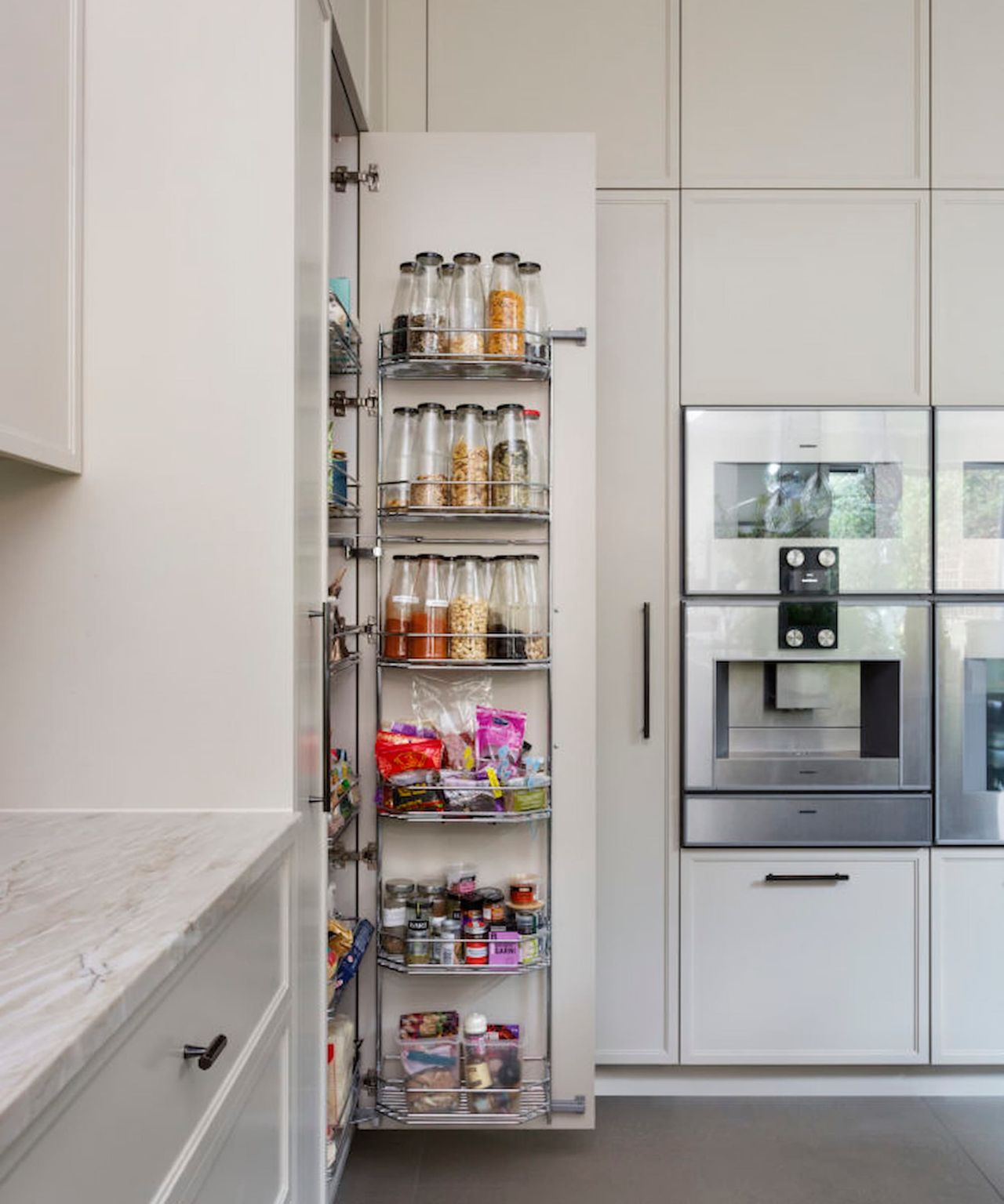 A hidden kitchen pantry with multiple shelves