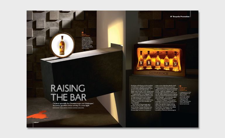 April issue spread showcasing six lit up bottle glorifiers of whisky designed by six international creatives, black square design wall, white divider wall, black floor