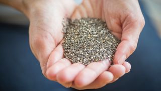 Person holding a handful of chia seeds