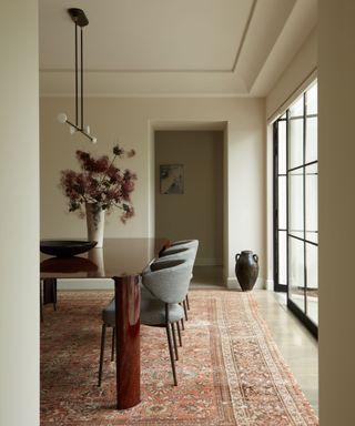 neutral dining room with vintage rug and fabric chairs