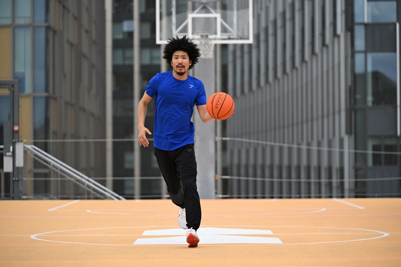 Person in playing basketball on a rooftop basketball court