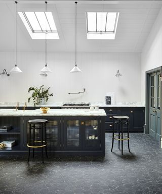 A kitchen with black island and black and gold luxury vinyl tile flooring with marble and gold hexagonal motif