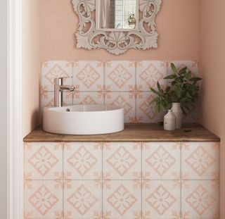 Pink patterned tiles around a bathroom sink