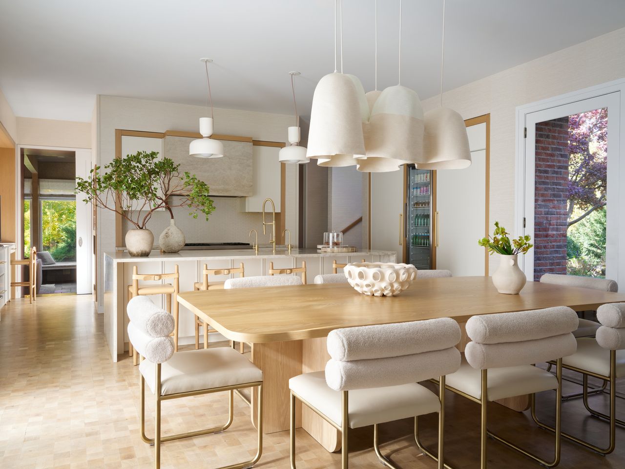 kitchen with light wood tones, white decor details, and greenery