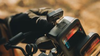 GoPro camera with a cable being attached to the Contacto battery door