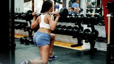 Woman lunging with a barbell on her shoulders