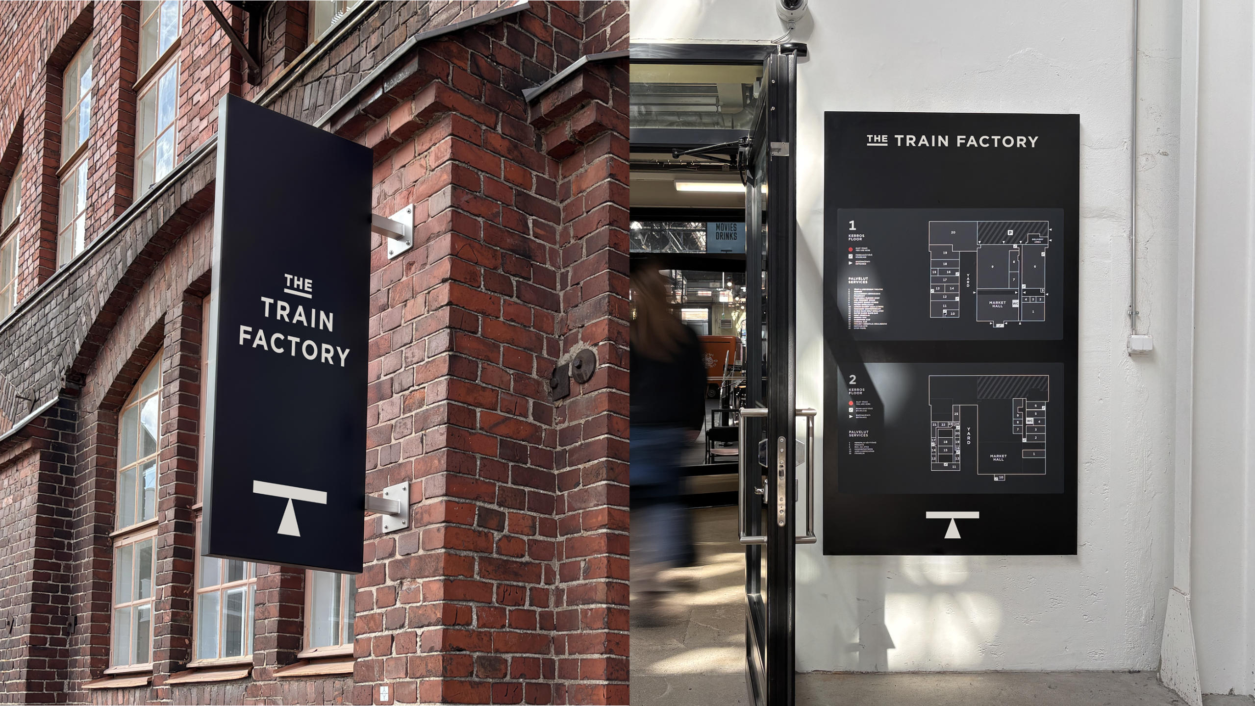 A dark wayfinding sign reading "The Train Factory" mounted on a red brick exterior corner, beside an open doorway and a black floor-plan directory sign showing venue locations across two levels.
