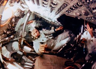an astronaut floats in a cramped capsule