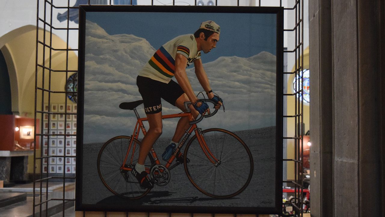 A painting of Eddy Merckx climbing out of the saddle while wearing the world champion's jersey