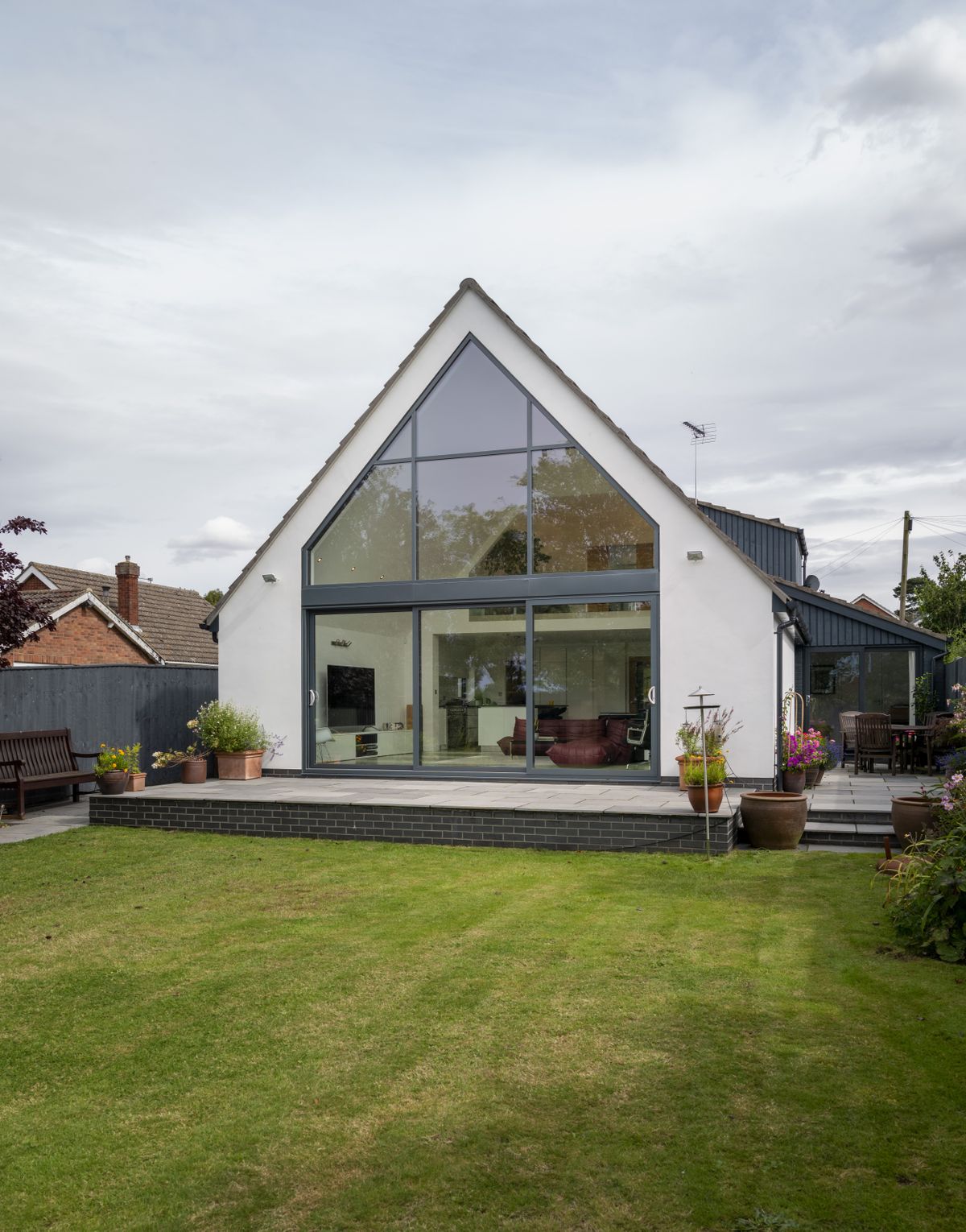 The double-height space that sits within the new extension houses the living area below, with views out through the fully glazed gable.