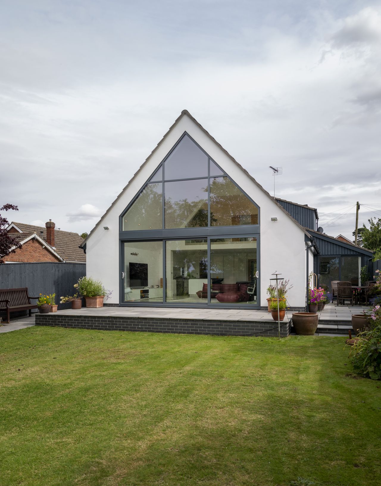 The double-height space that sits within the new extension houses the living area below, with views out through the fully glazed gable.