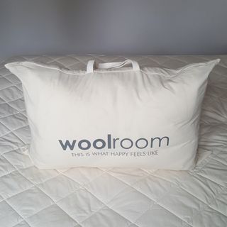 The Woolroom Deluxe Washable Wool Mattress Protector being tested on a mattress in a bedroom