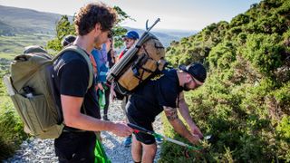 Hikers picking up litter on trail
