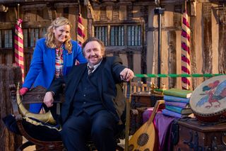 Shakespeare & Hathaway season 4: Frank Hathaway (Mark Benton) relaxes on a bench outside their office while Lu Shakespeare (Jo Joyner) leans on the backrest. To the right of the picture is a pile of books of collected works of Shakespeare, along with a lute and a tambourine