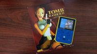Super Pocket Capcom edition next to big box copy of Tomb Raider 2 for PC