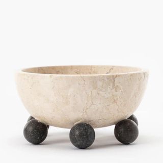 A marble bowl with dark round feet