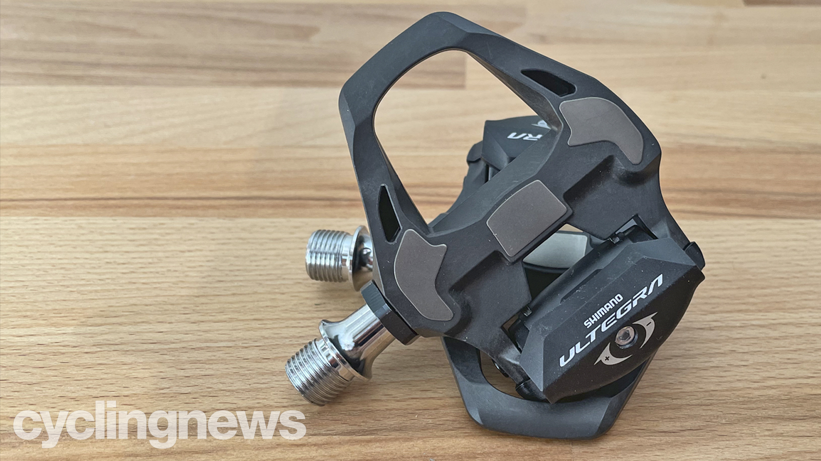 A pair of Shimano Ultegra pedals on a wooden bench