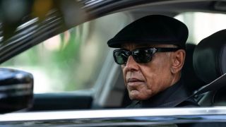 Gray Parish (Giancarlo Esposito), wearing dark sunglasses and a cap, stares from a car window in 