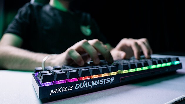 player types on gaming keyboard with multicolored backlighting