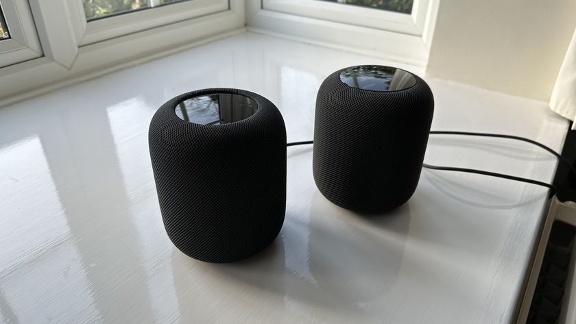 An Apple HomePod and Apple HomePod 2 speaker sit side-by-side on a white surface.