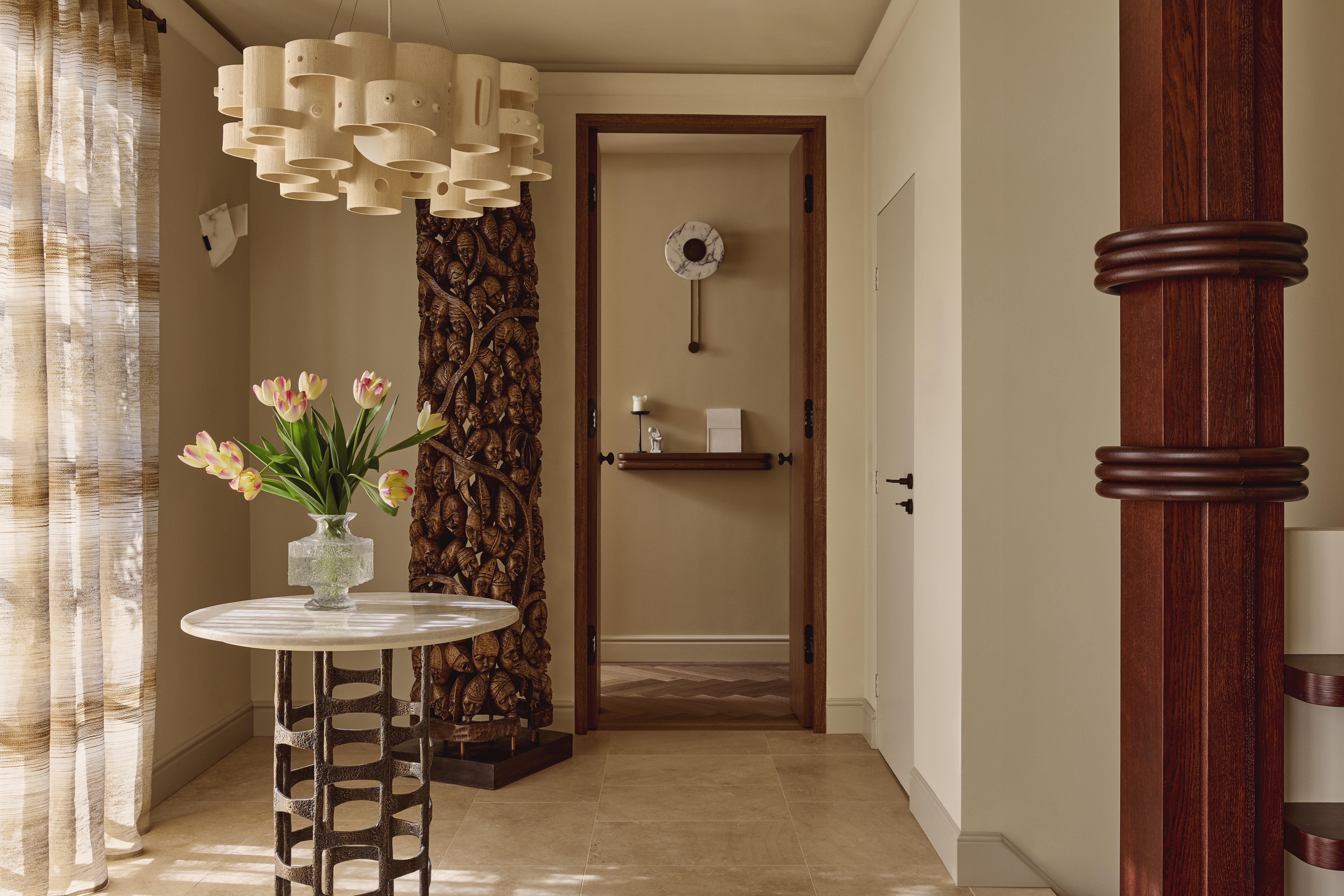 Entryway with table, wood sculpture and bespoke column wrapped in walnut timber